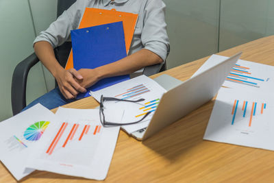 Midsection of business colleagues working on table