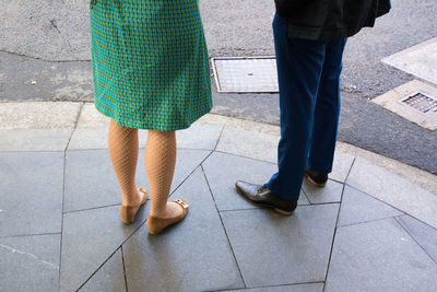 Low section of couple standing on sidewalk
