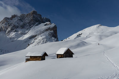 Built structure on snow covered mountain against sky