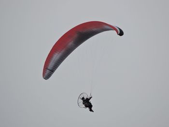 Low angle view of person paragliding against sky