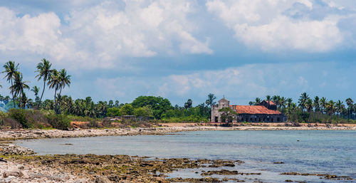 Scenic view of beach by buildings against sky