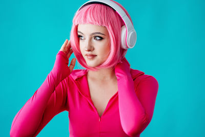 Portrait of young woman against blue background