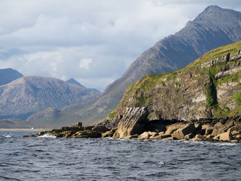 Scenic view of sea and mountains against sky