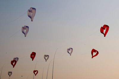 Low angle view of kites flying in sky