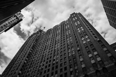 Low angle view of modern building against cloudy sky