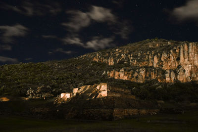 Houses on field against sky at night