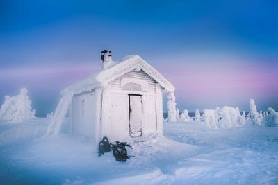 Built structure on snow covered field against sky