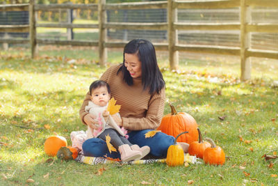 Mother and daughter sitting on grass at park