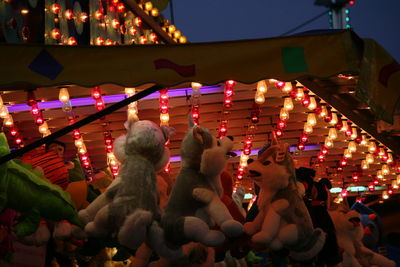 People at illuminated temple against sky at night