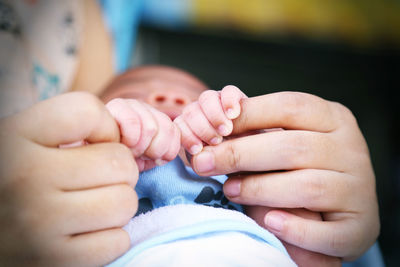 Close-up of mother holding baby hand