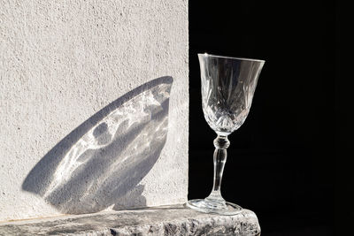 Close-up of glass on table against wall