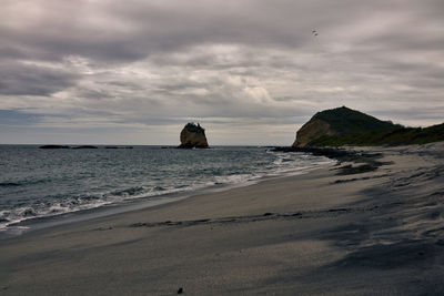 Scenic view of rocks on beach against sky