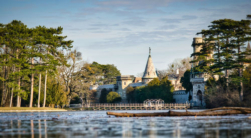 View of river by buildings against sky