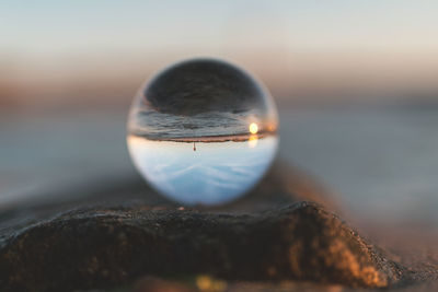 Close-up of rock in sea against sky