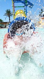 Person splashing water in slide at park