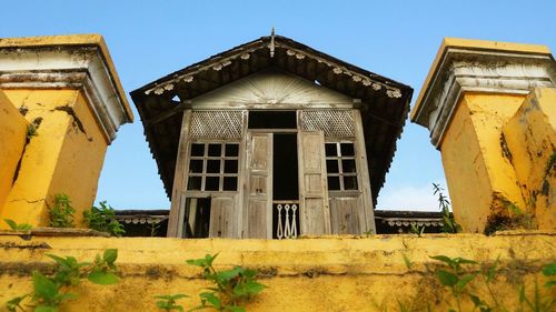 Low angle view of old building against clear blue sky