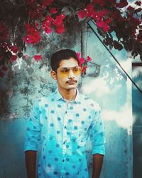 Portrait of young man wearing sunglasses standing outdoors