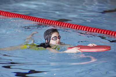 Girl learning to swim in indoor swimming pool