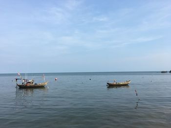 People in boat on sea against sky