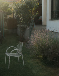 Empty chairs and table in yard