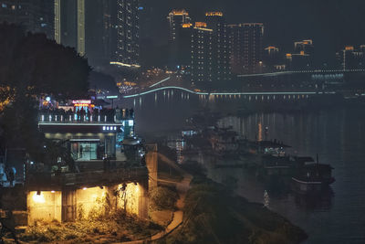 High angle view of illuminated buildings by river at night