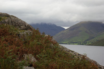 Scenic view of river and mountains against sky