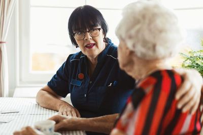 Caretaker talking to senior woman at home