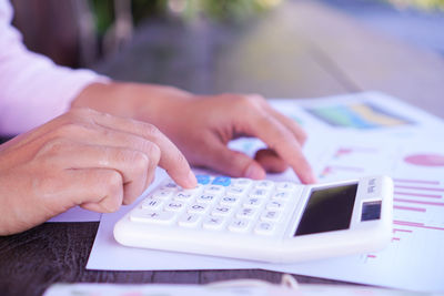 Close-up of man using smart phone on table