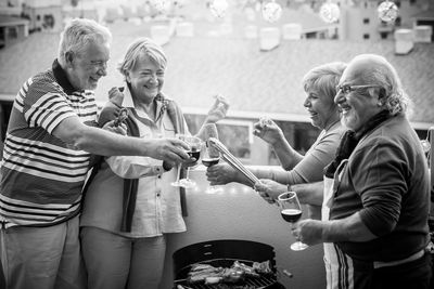 Happy couple toasting wineglasses against sky