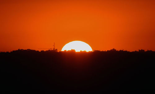 Scenic view of silhouette landscape against orange sky