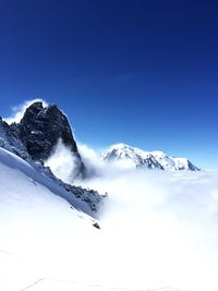 Scenic view of snowcapped mountains against cloudy sky