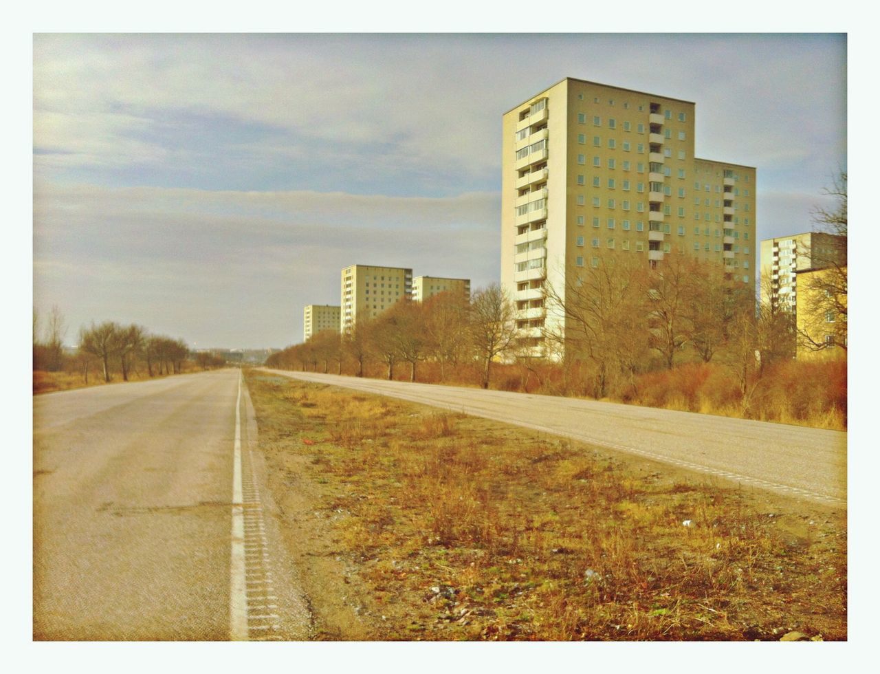 the way forward, building exterior, architecture, built structure, transfer print, diminishing perspective, sky, transportation, vanishing point, auto post production filter, road, city, road marking, street, surface level, empty, day, outdoors, no people, cloud - sky