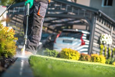 Low section of man spraying water while standing at yard