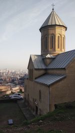 Church amidst buildings in city against sky