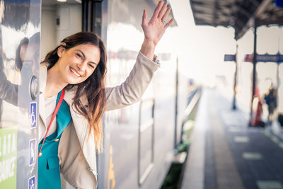 Portrait of smiling young woman standing in city