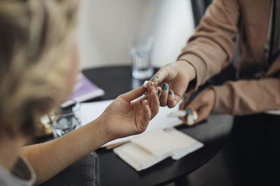 Mental health professional giving tampon to teenage female student