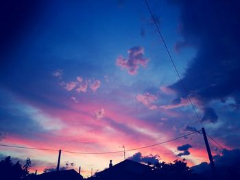 Low angle view of silhouette power lines against sky during sunset