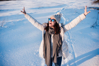 Happy young woman hiking in snowy mountain wearing modern coat at sunset. winter season. nature