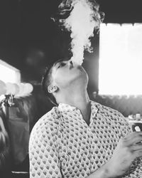 Portrait of young man smoking outdoors