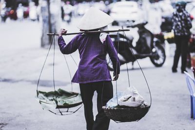 Rear view of woman selling food on street in city