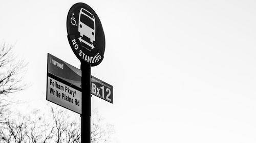 Low angle view of road sign against clear sky