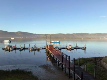 Pier on lake against clear sky