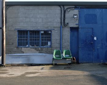 Empty chairs against building in city