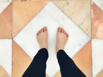 Low section of woman standing on tiled floor