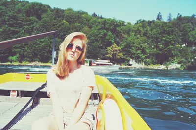 Portrait of beautiful young woman on boat sailing in river