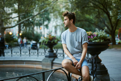 Young man sitting on bicycle in city