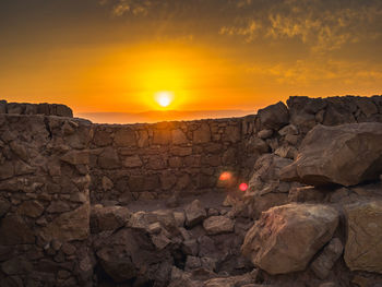 Rock formation against sky during sunset
