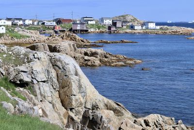 Scenic view of sea by buildings against sky