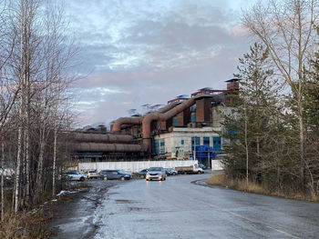 Cars on road by buildings against sky