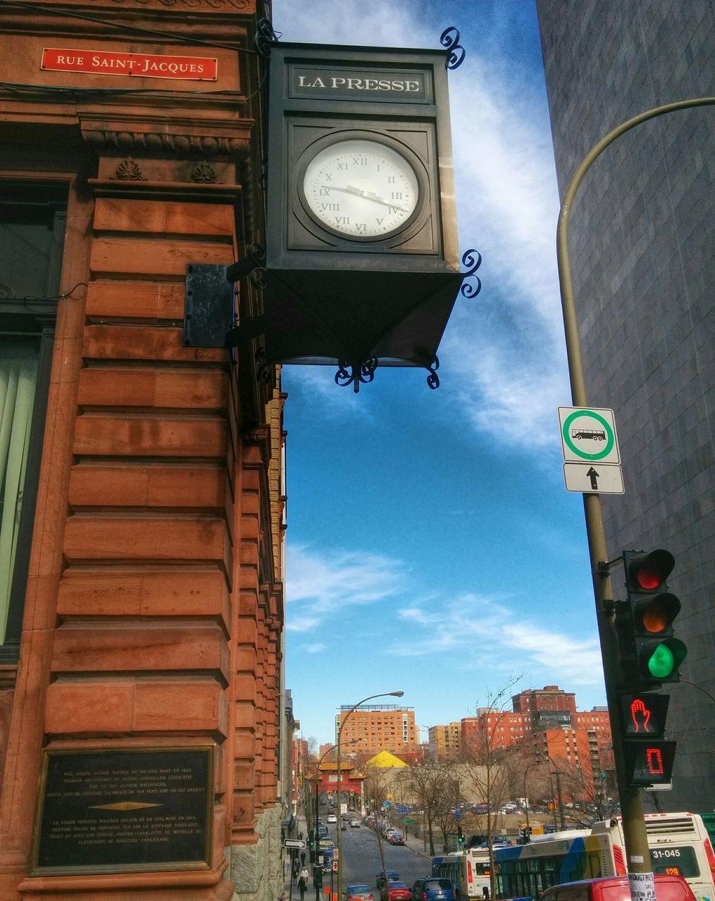 architecture, building exterior, built structure, text, communication, clock, low angle view, road sign, western script, clock tower, city, sky, time, transportation, information sign, street, guidance, car, sign, outdoors